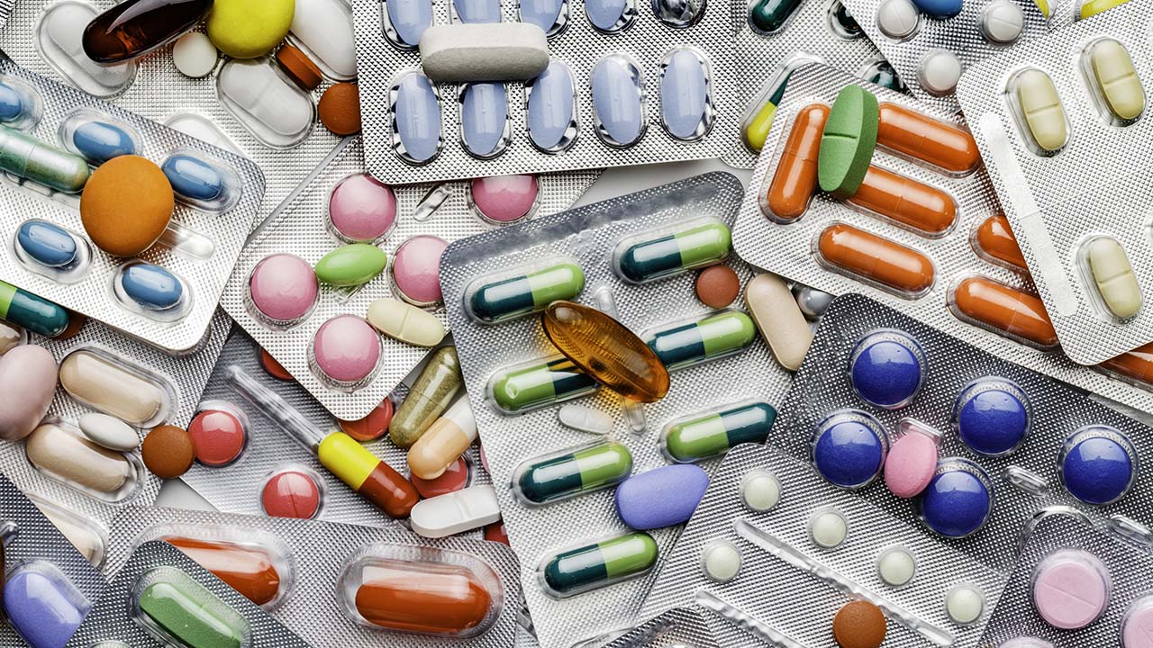 Health themes. Background of a large group of assorted capsules, pills and blisters. Drug abuse.