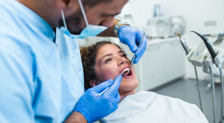 dentist-examining-teeth-of-female-patient